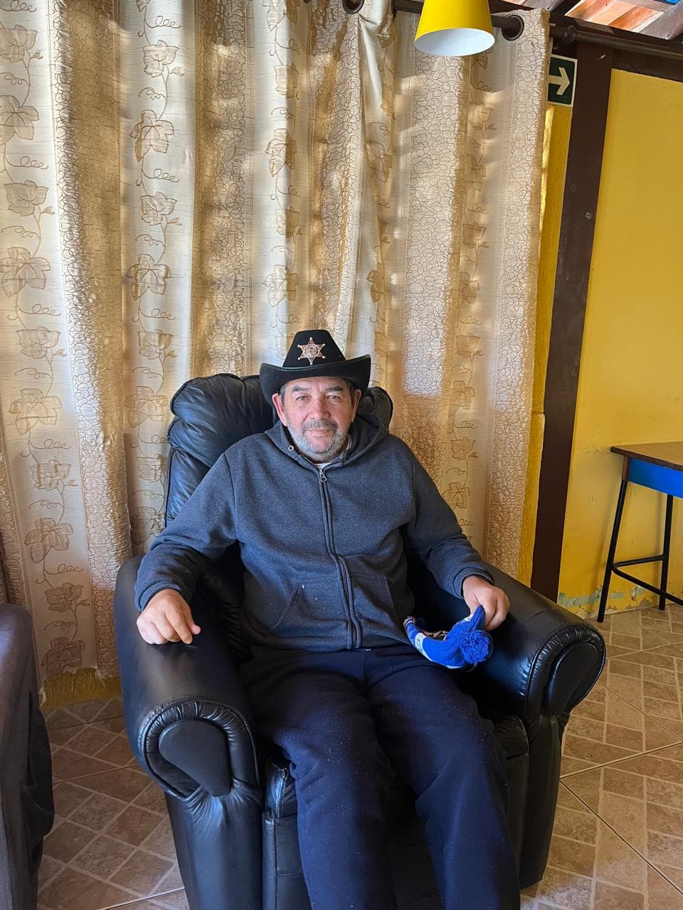 Residente na sala de estar da casa de repouso Residencial Aliança
